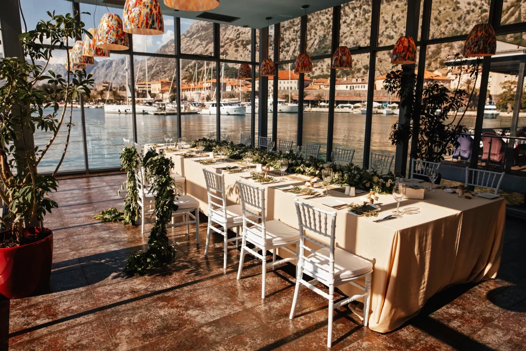 wedding reception room with decorated table setting sea view through window